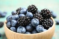 Blueberries and blackberries wooden in bowl