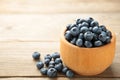 Blueberries in a bowl on grey wooden table with copy space