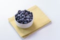 Blueberries bowl with yellow cloth in white backdrop Royalty Free Stock Photo