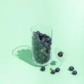 Blueberries fall out of a broken glass on a green background Royalty Free Stock Photo