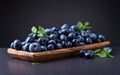 Blueberries with green leaves in wooden dish Royalty Free Stock Photo