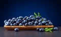 Blueberries with green leaves in wooden dish Royalty Free Stock Photo