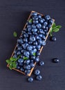 Blueberries with green leaves in wooden dish Royalty Free Stock Photo