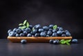 Blueberries with green leaves in wooden dish Royalty Free Stock Photo