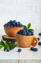 Blueberries with leaves in a clay cup
