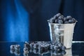 Blueberries in a metal bucket closeup on a blue background. Multivitamin cocktail. Healthy lifestyle. Summer diet.