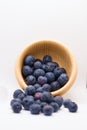Blueberries spilling out of overturned wooden bowl Royalty Free Stock Photo