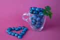 blueberries in a transparent cup and blueberry heart Royalty Free Stock Photo