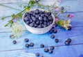 Blueberries and wild flowers on blue planks
