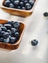 Blueberries in wooden bowls isolated on white background. Low angle view. Close-up. Vitamins, antioxidants. Healthy organic food,