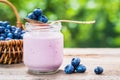 Blueberries yogurt in jar, basket of berries and saucer