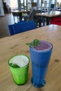 Blueberry and banana milkshakes with mint leaves on a wooden table in a cafe