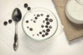 Blueberry berry in a glass deep plate with milk on a white table. breakfast concept, healthy food, vitamins