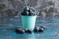 Blueberry berry in a small decorative bucket on a blue concrete background Royalty Free Stock Photo