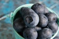 Blueberry berry in a small decorative bucket on a blue concrete background macro Royalty Free Stock Photo