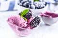 Blueberry and blackberry ice cream in bowl with frozen fruits