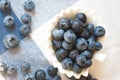 Blueberry closeup. Freshly picked blueberries in wooden bowl over rustic background.
