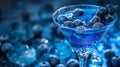 Blueberry cocktail in martini glass with ice cubes on blue background Royalty Free Stock Photo