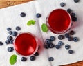 Blueberry fruit infused drinks with ice cubes in glasses, top view on a natural linen background Royalty Free Stock Photo