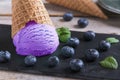 Blueberry ice cream in a waffle cup on a stone surface Royalty Free Stock Photo