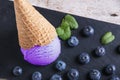 Blueberry ice cream in a waffle cup on a stone surface Royalty Free Stock Photo