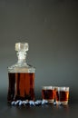 Blueberry liqueur liqueur, strong homemade alcohol in a glass decanter and two glasses on a black background, next to a bunch of Royalty Free Stock Photo