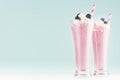 Blueberry milkshake with berry, whipped cream, striped straw in two high transparent glass on white wood table and mint color wall Royalty Free Stock Photo