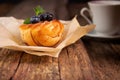 Blueberry muffin and berries with a cup of tea on an old wooden board Royalty Free Stock Photo