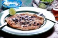 Blueberry pancake on green plate with knife and fork