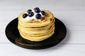 Blueberry pancakes on black plate on white board table Royalty Free Stock Photo