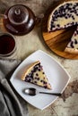 Appetizing blueberry pie on a wooden plate, a piece of blueberry pie on a white plate and a Cup of hot tea on a beautiful gray bac Royalty Free Stock Photo