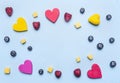 Blueberry raspberry and mango, decorative hearts lined frame on blue background, space for text