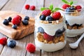 Blueberry, raspberry parfaits in mason jars, still life over wood