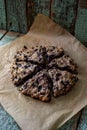 Blueberry rustic scones on bake paper and oak cutboard on old painted wood background