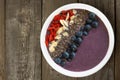 Blueberry smoothie bowl with super-foods on rustic wood