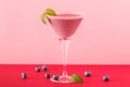 Blueberry smoothie cup with several blueberries on a red and pink background