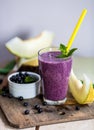 Blueberry smoothie in a glass with a straw and sprig of mint, ov Royalty Free Stock Photo