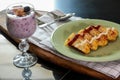 Blueberry Smoothie Yogurt, with the cashew nuts and almond in the glass, and Omelette in the green plate on wooden table