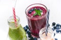 Blueberry, spinachy and orange smoothie on a wooden white background. Glasses of smoothie with berry and mint. Berry, leaf and lim Royalty Free Stock Photo