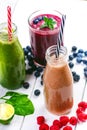 Blueberry, spinachy and orange smoothie on a wooden white background. Glasses of smoothie with berry and mint. Berry, leaf and lim Royalty Free Stock Photo