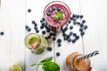 Blueberry, spinachy and orange smoothie on a wooden white background. Glasses of smoothie with berry and mint. Berry, leaf and lim Royalty Free Stock Photo