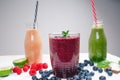 Blueberry, spinachy and orange smoothie on a wooden white background. Glasses of smoothie with berry and mint. Berry, leaf and lim Royalty Free Stock Photo