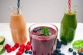 Blueberry, spinachy and orange smoothie on a wooden white background. Glasses of smoothie with berry and mint. Berry, leaf and lim Royalty Free Stock Photo