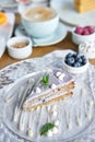 Blueberry sponge cake decorated with meringue and mint leaves.. Breakfast in the cafe, morning coffee. Cappuccino and Royalty Free Stock Photo