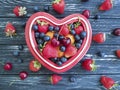 Blueberry, strawberry cherry plate heart on old black wooden Royalty Free Stock Photo