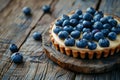 Blueberry tart with custard on rustic wooden board. Sweet fruit dessert