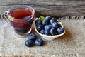 Blueberry tea in a glass cup and fresh blueberries on a burlap cloth on wooden background.Natural herbal beverage. Royalty Free Stock Photo