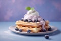 Blueberry waffles with cream on pastel colored background