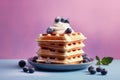 Blueberry waffles with cream on pastel colored background