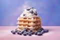 Blueberry waffles with cream on pastel colored background